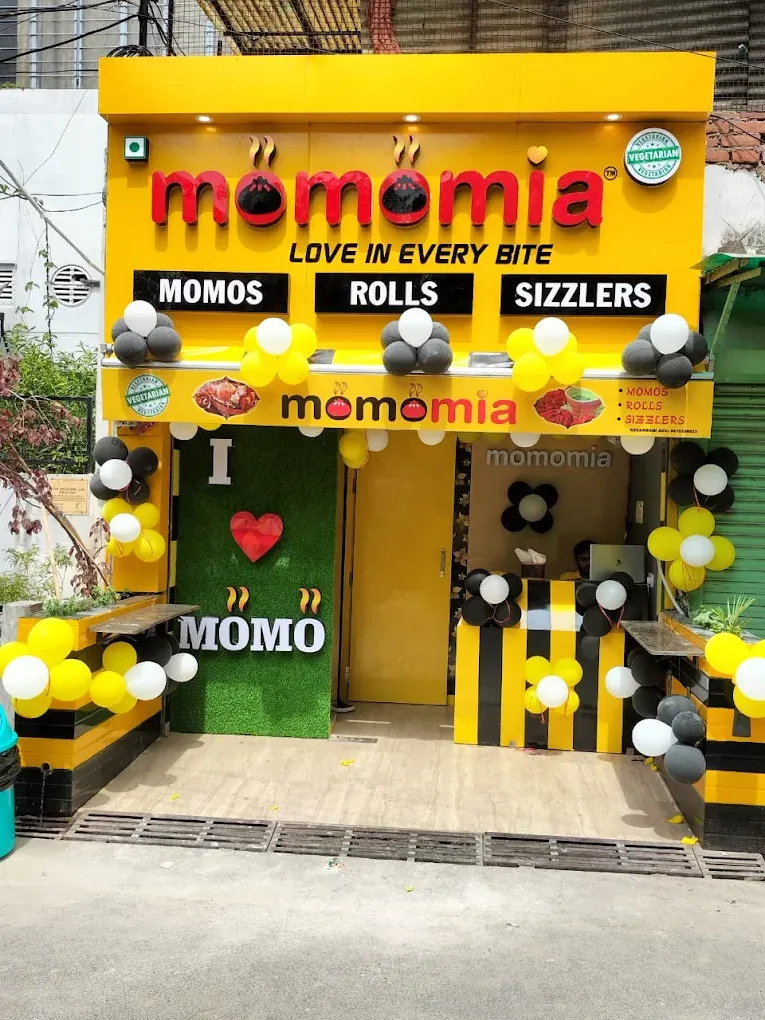 Vibrant yellow ACP facade with 3D LED letters for Momomia restaurant storefront